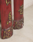 Close-up of carved lower ends with worn red and gilt finish on Chinese panels
