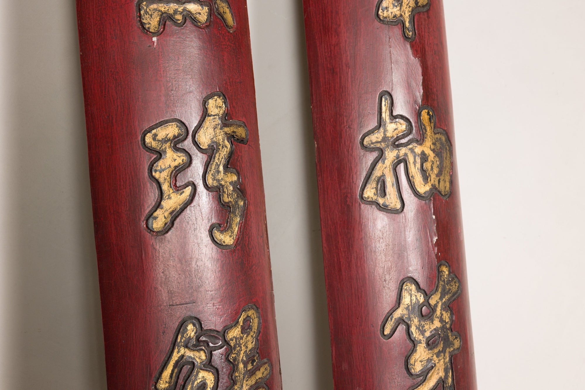 Center detail of gilt Chinese characters on paired red lacquered wood panels