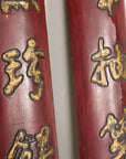 Center detail of gilt Chinese characters on paired red lacquered wood panels