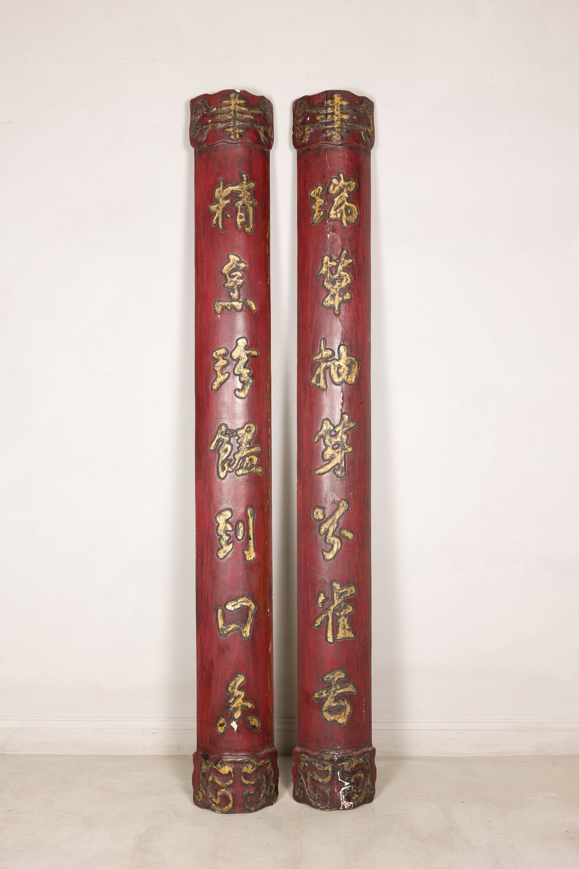 Front view of paired red Chinese panels with gilt calligraphy and carved ends