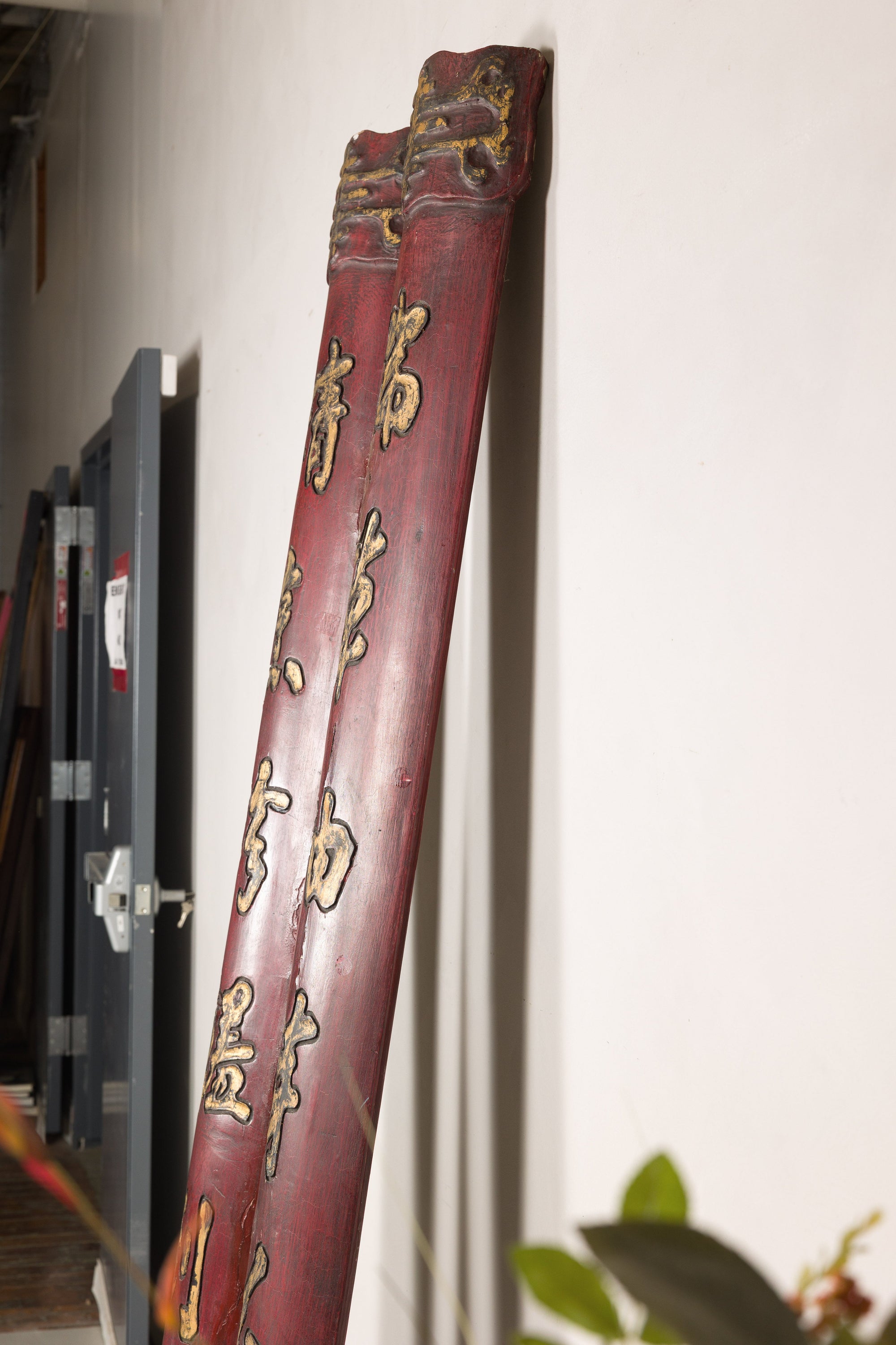Full view of paired red Chinese wood panels with vertical gilt calligraphy