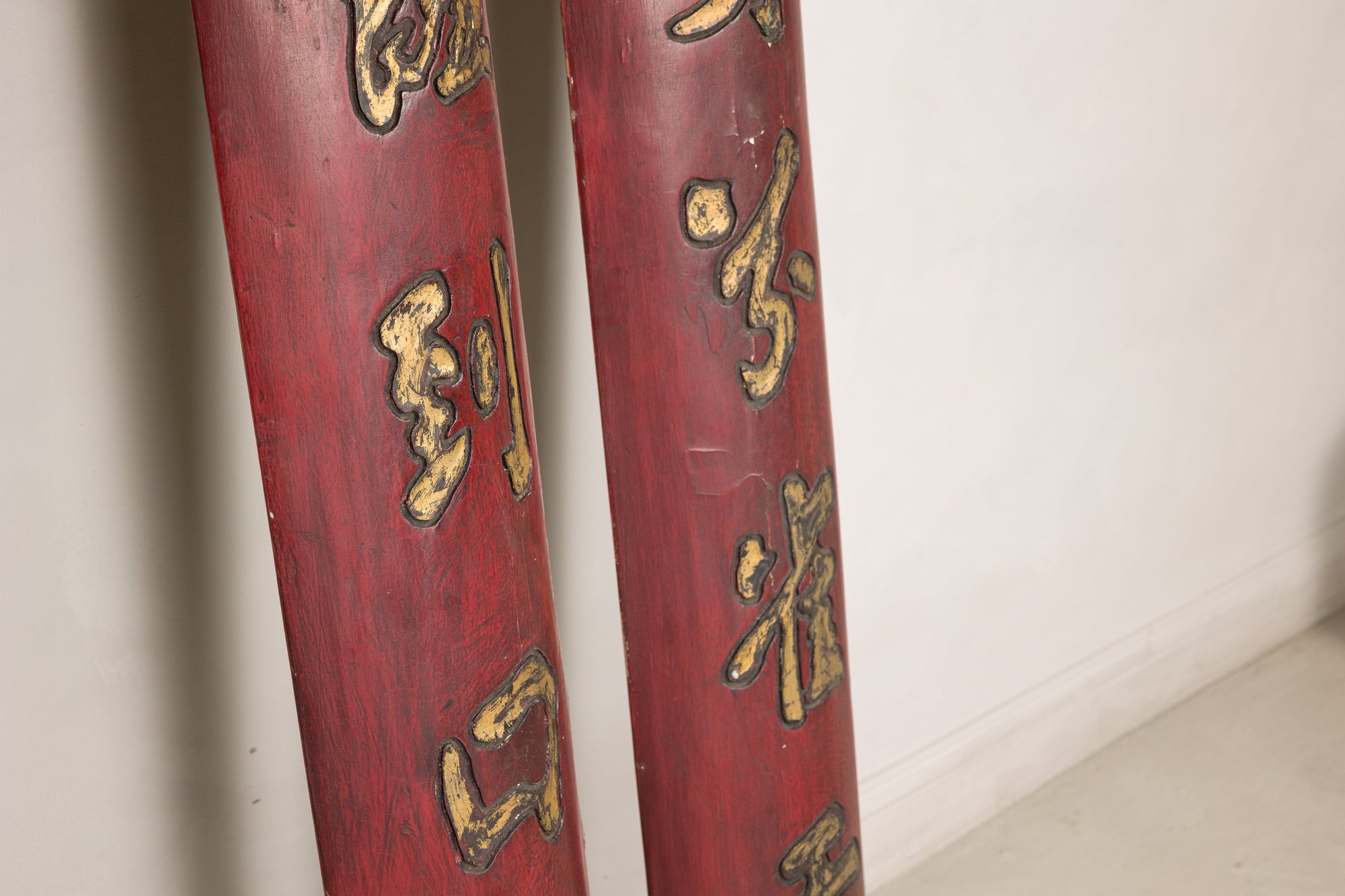 Close-up of lower gilt characters and worn red finish on Chinese wood panels