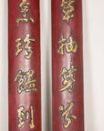 Upper detail of paired red calligraphy panels showing gilt finish and age cracks