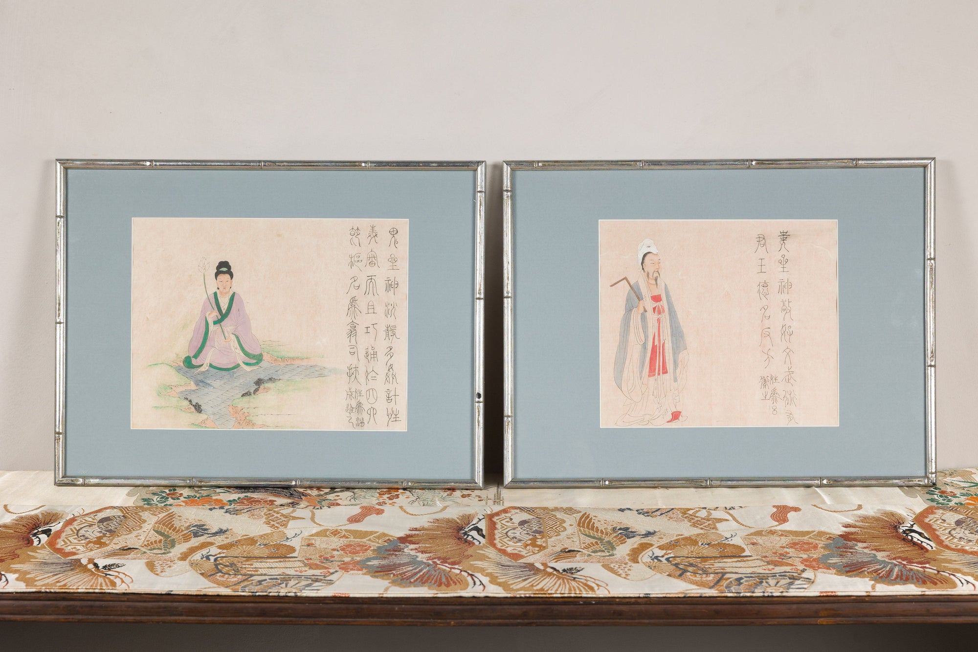 Front view of two Japanese figural prints with pale blue mats
