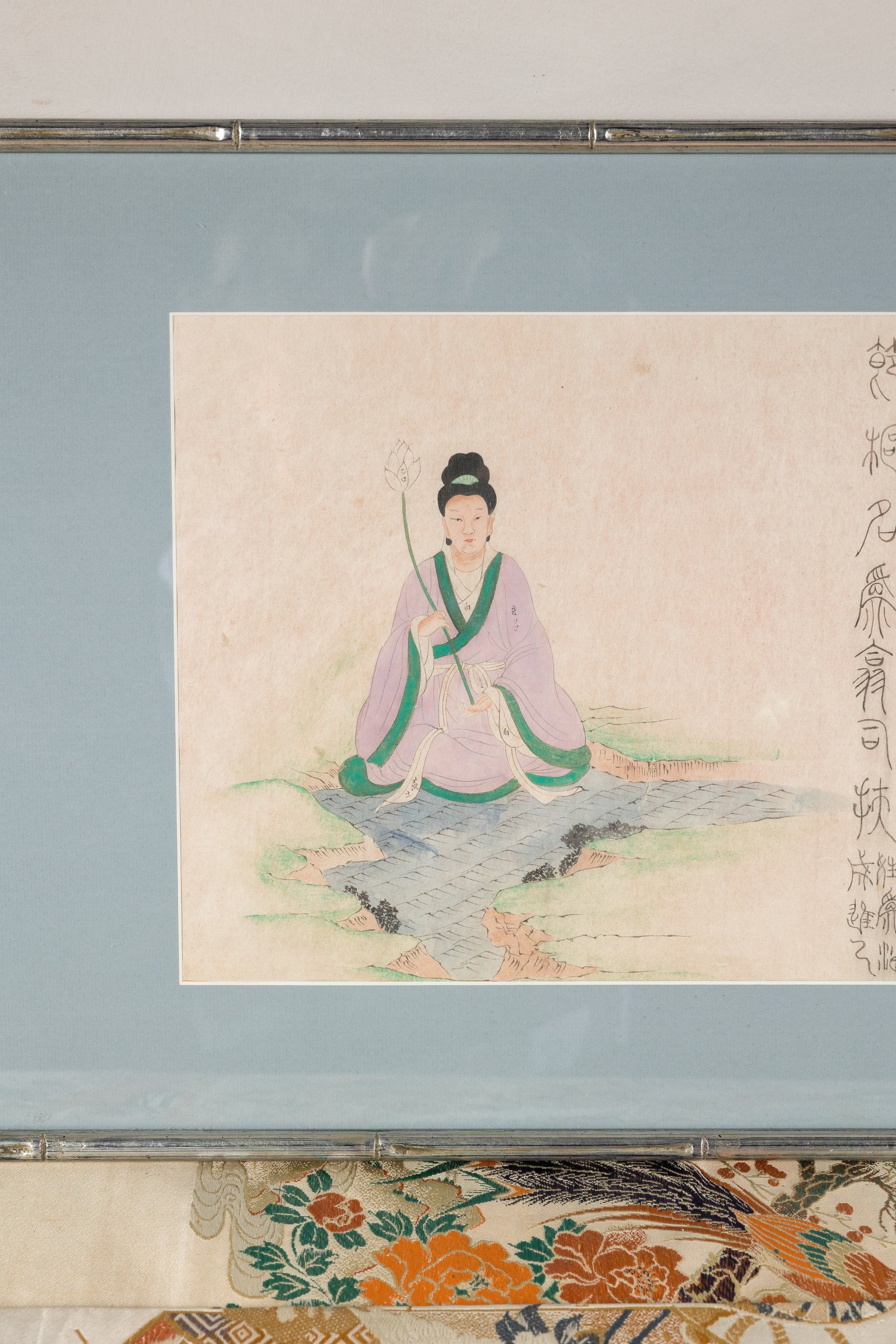 Close-up of the seated Japanese figure against a pale blue mat