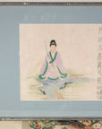 Close-up of the seated Japanese figure against a pale blue mat