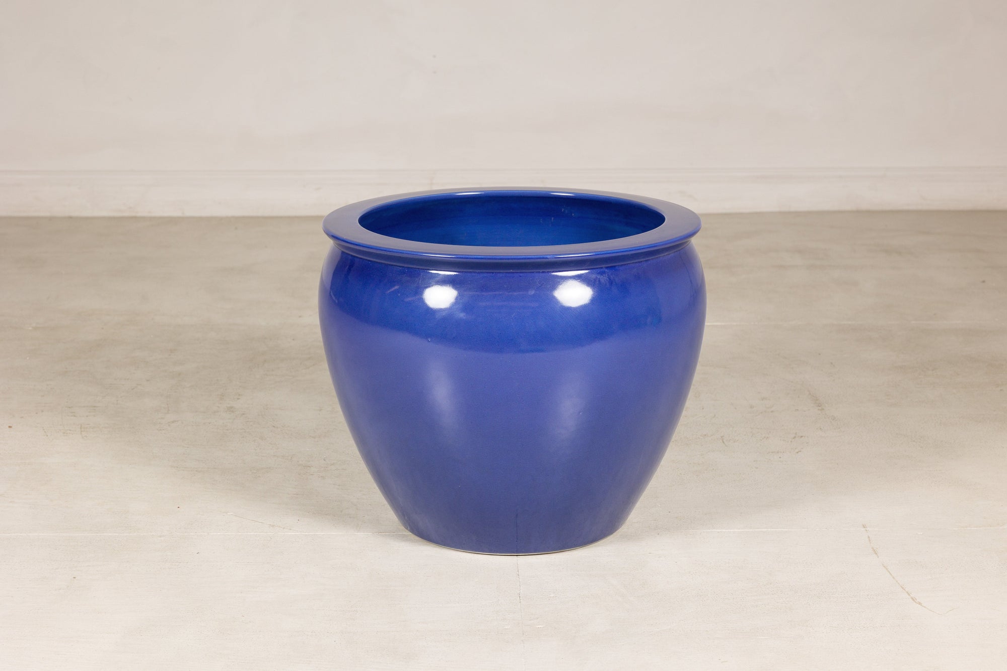 Cobalt blue ceramic planter shown from the front in a studio setting