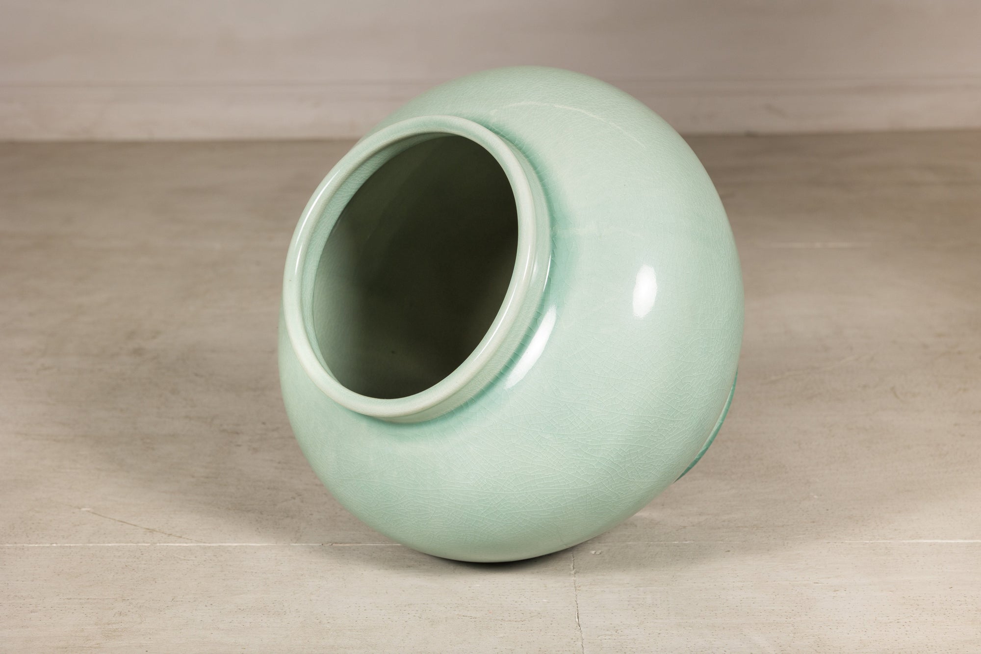 Angled view into the open mouth of the celadon ceramic vase