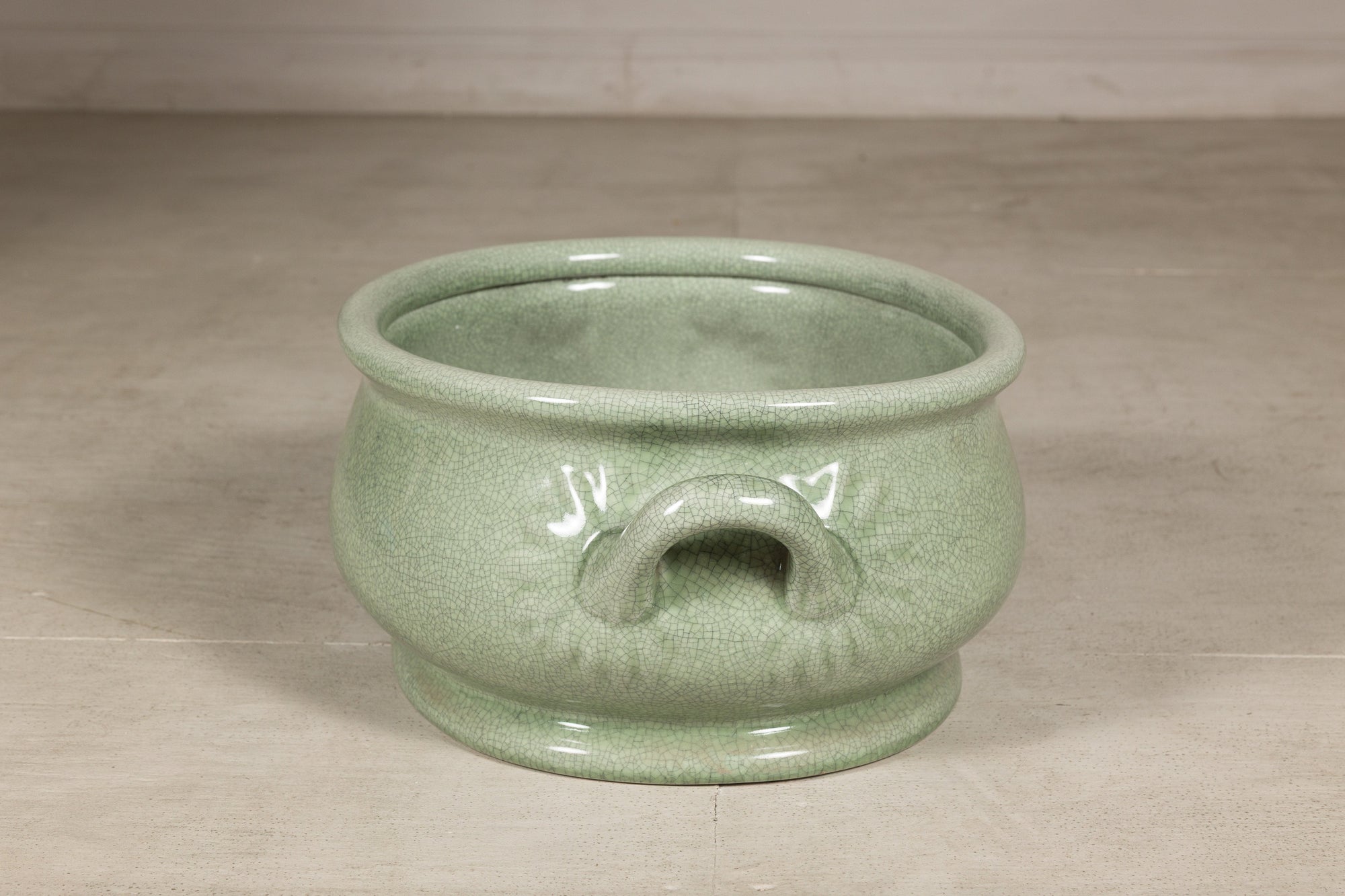 Front view of the celadon footbath centered on one loop handle