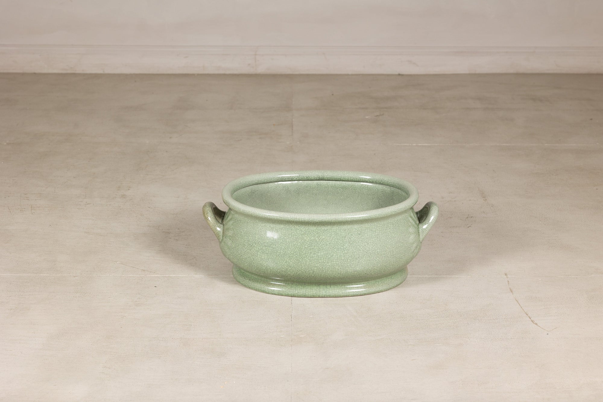 Celadon ceramic footbath shown at smaller scale in a studio setting