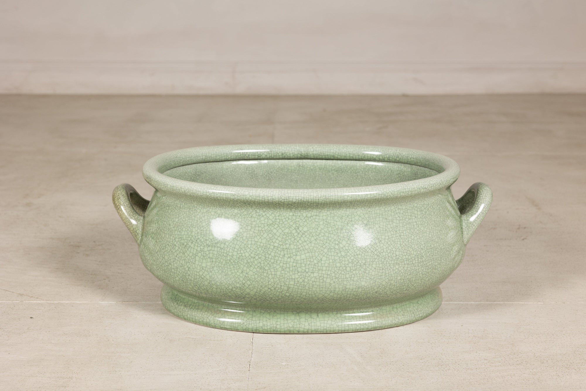 Side view of the celadon footbath with both loop handles visible