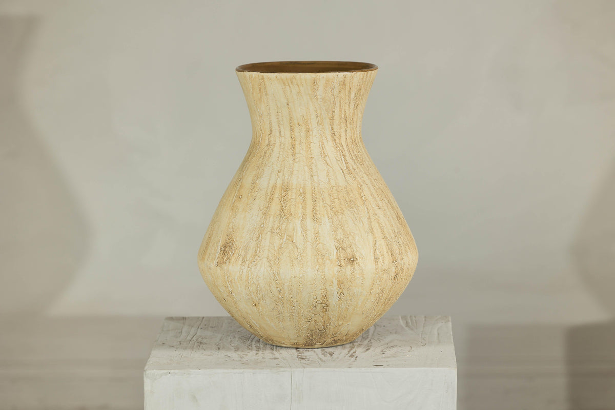 Beige ceramic vase with textured drip glaze and flared neck on a white pedestal.