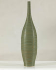 Olive-green ribbed ceramic artisan vase on white surface.