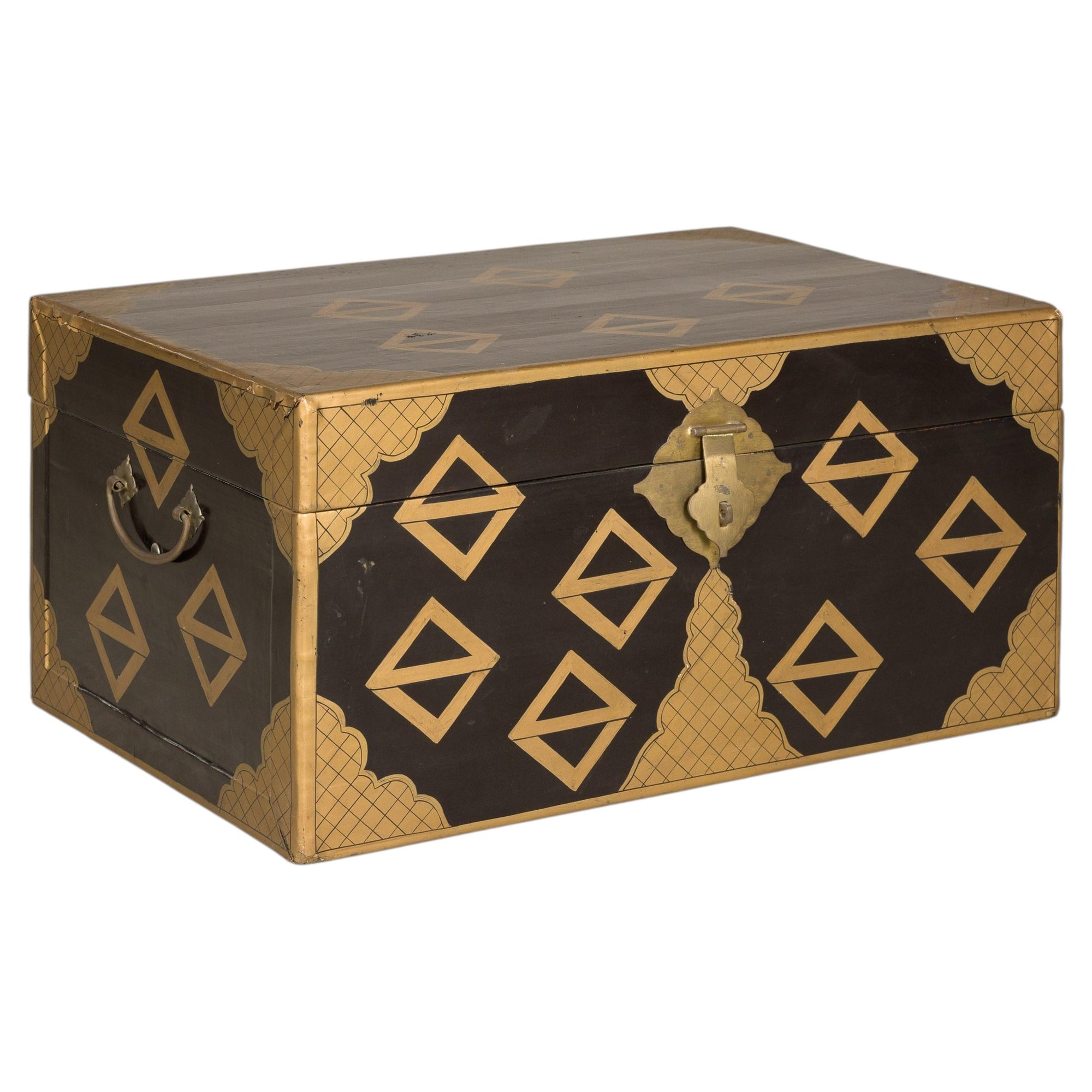 Black lacquered vintage Chinese chest with gold geometric pattern, metal handles, and front latch, close-up view.