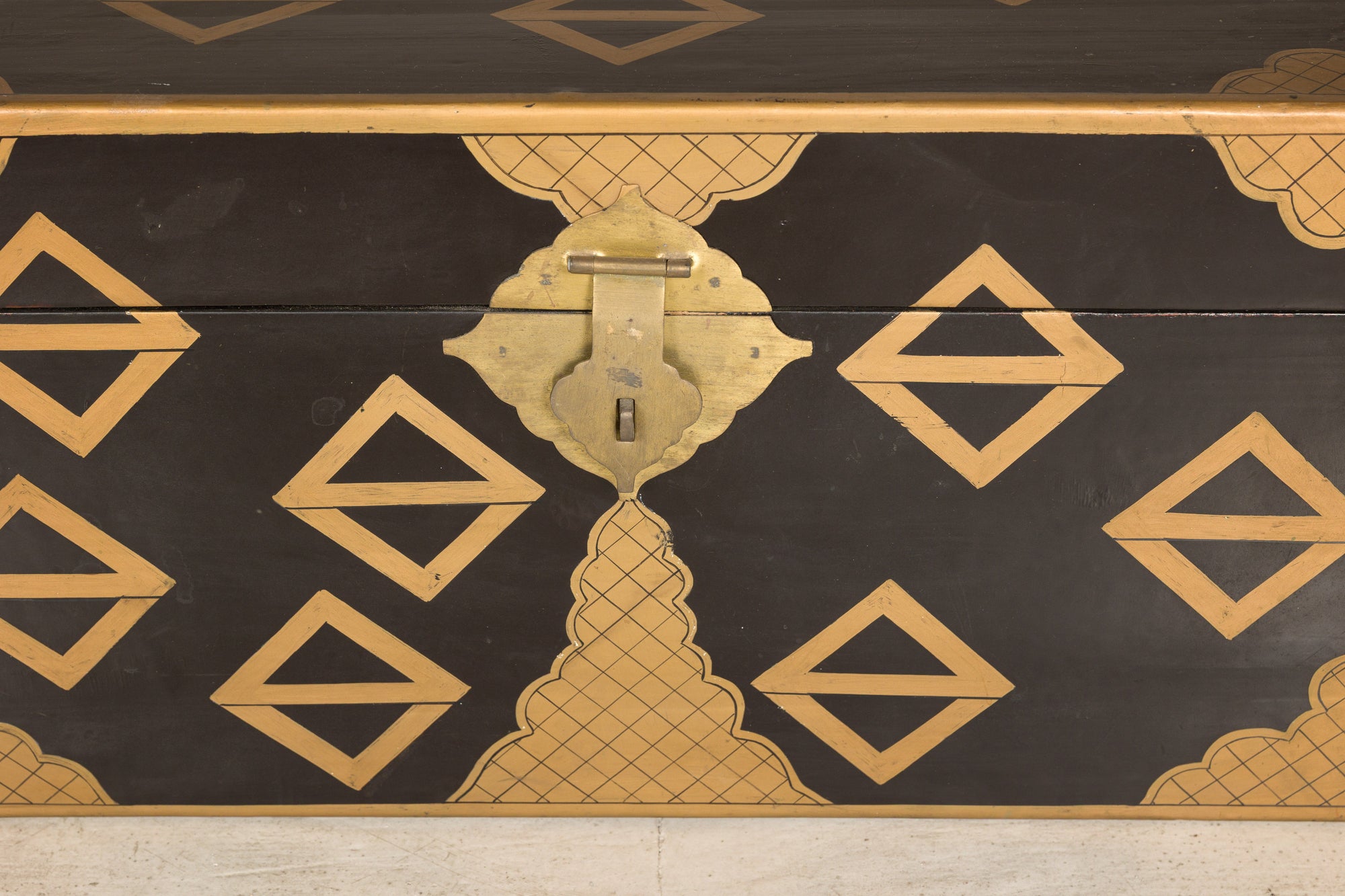 Close-up of chest lock and gold geometric motifs