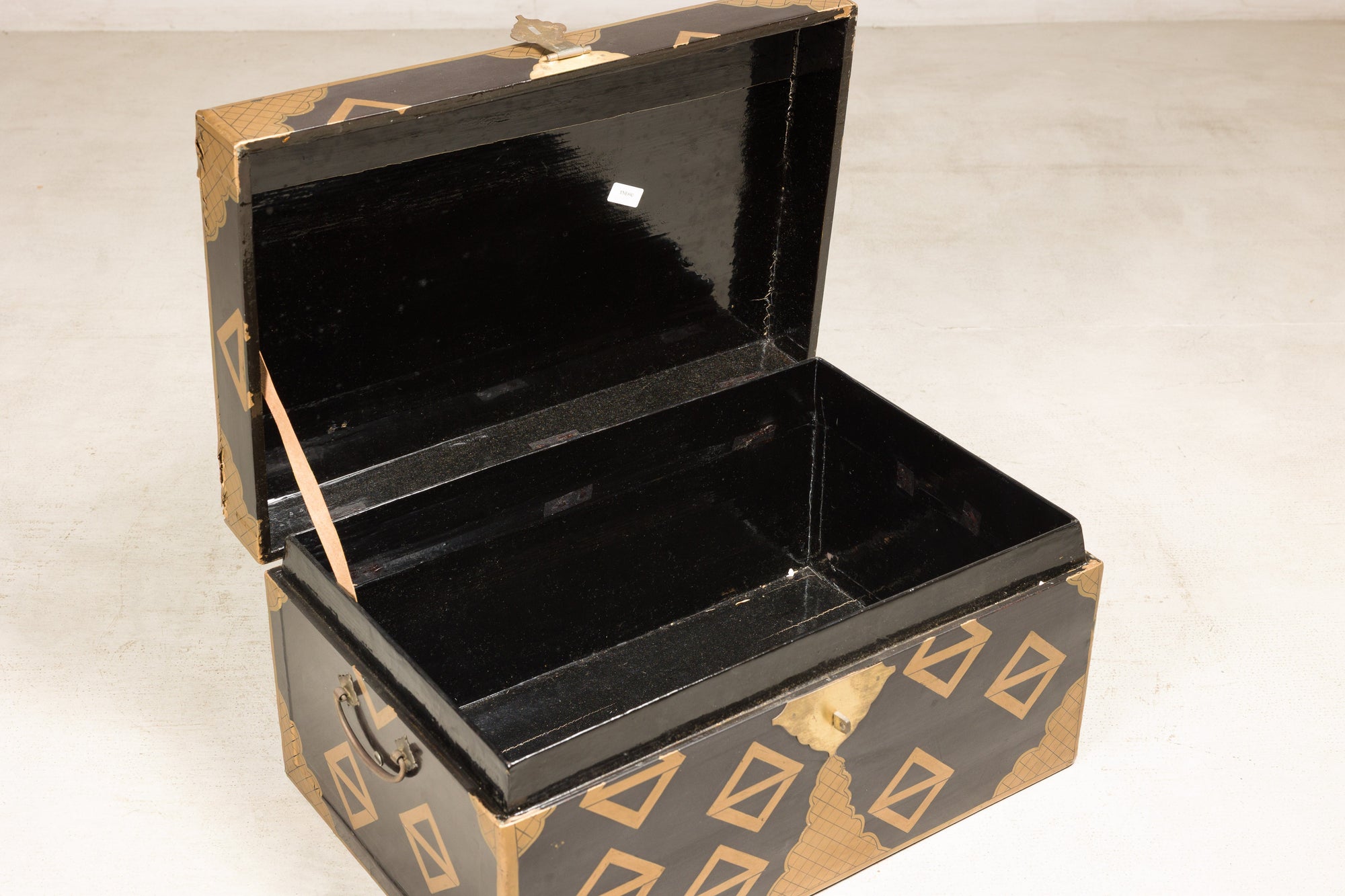 Open black lacquered chest showing interior storage