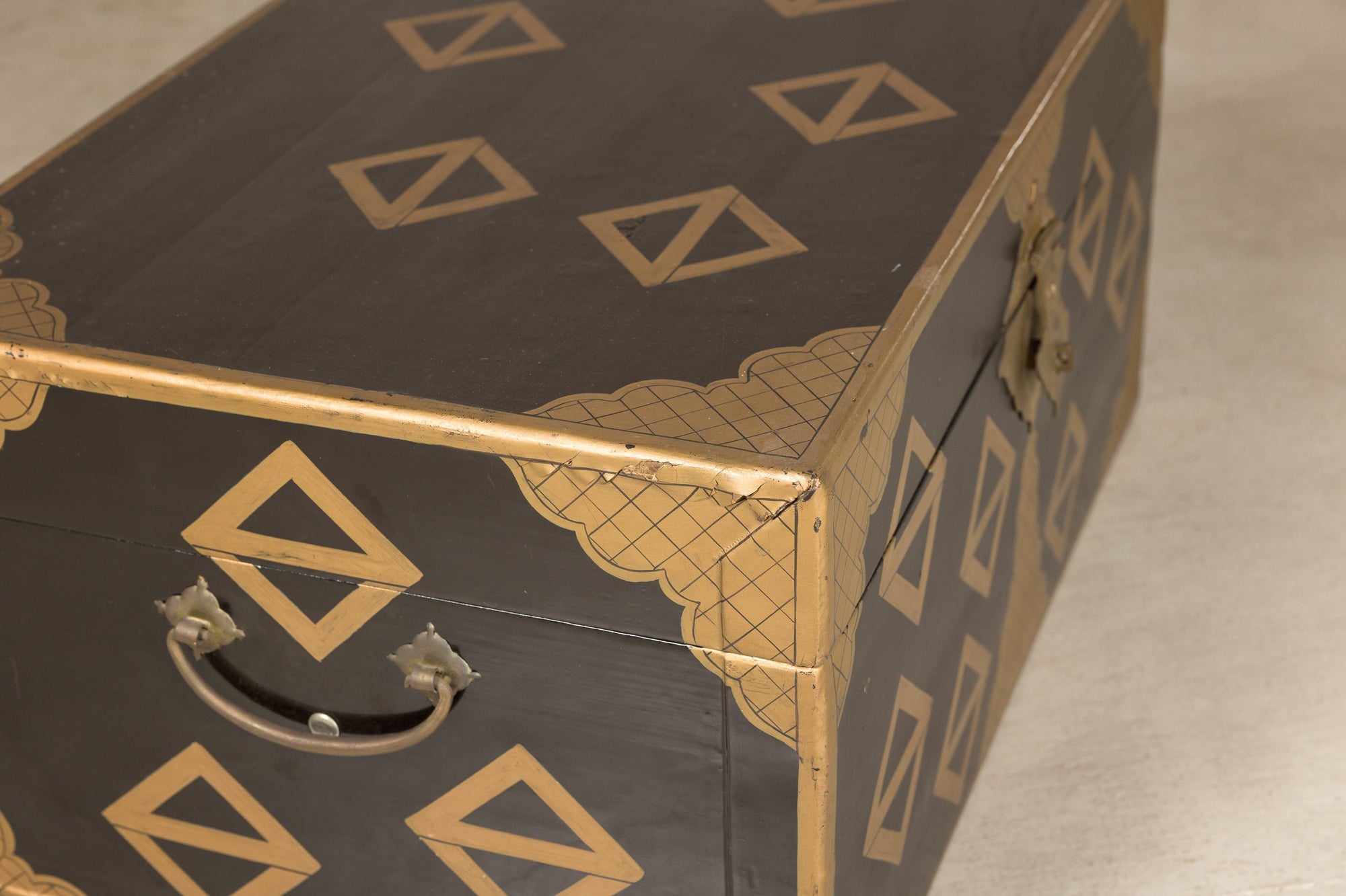 Close-up of lacquered chest corner and metal handle