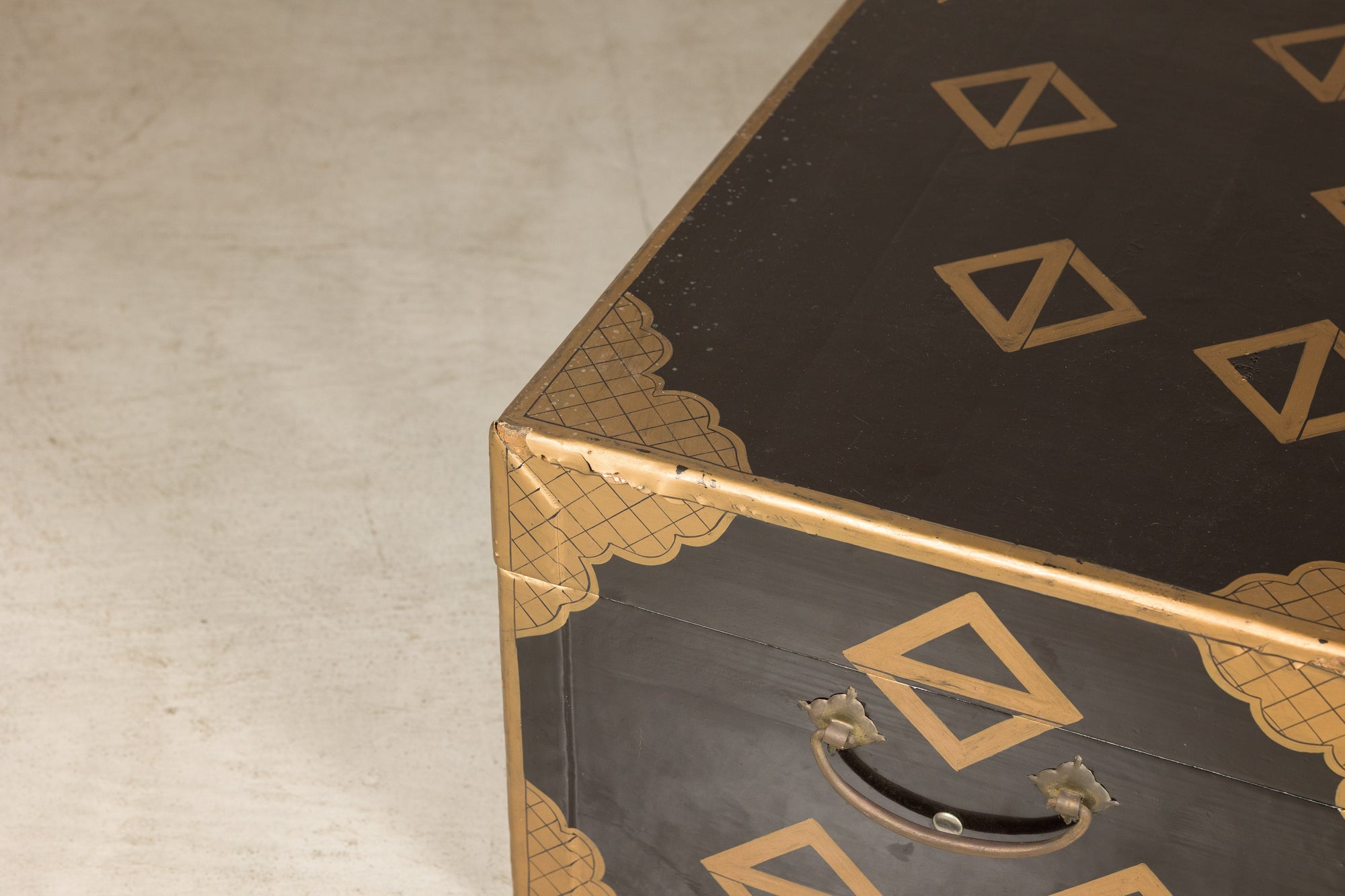 Close-up of black lacquered lid and worn corner