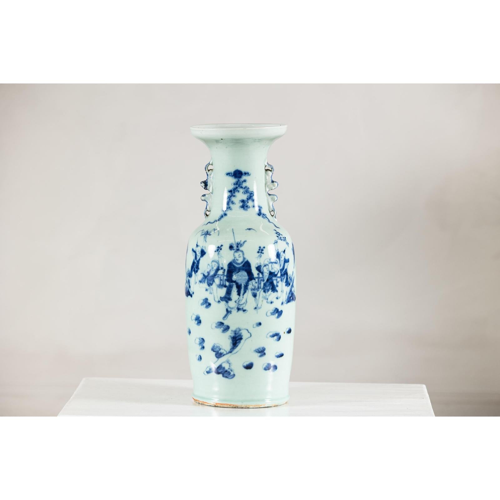 Blue and white ceramic vase with painted scenes and celadon glaze, displayed on a white surface.