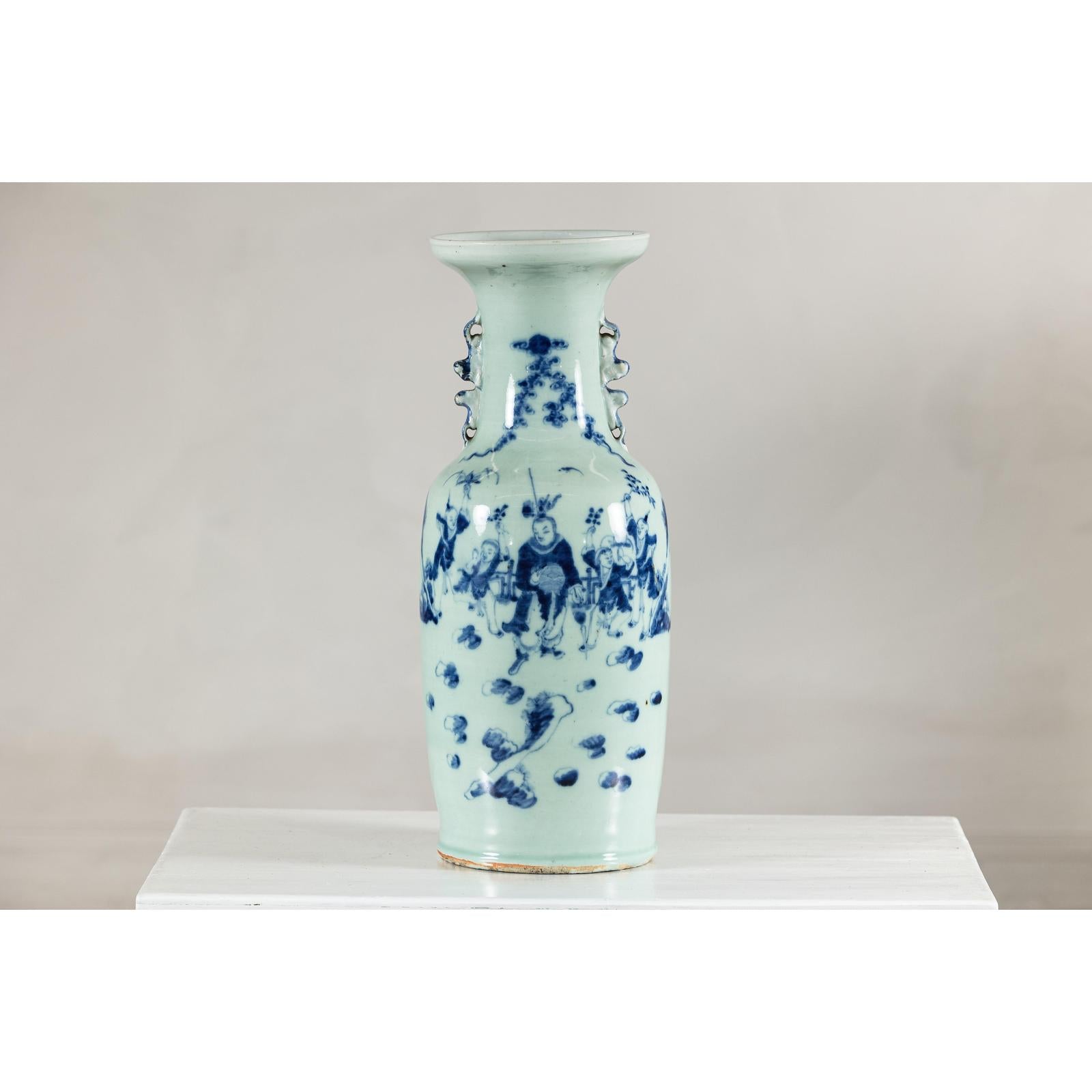 Blue and white porcelain Chinese vase with painted scenes, celadon glaze, and decorative handles, close-up view.