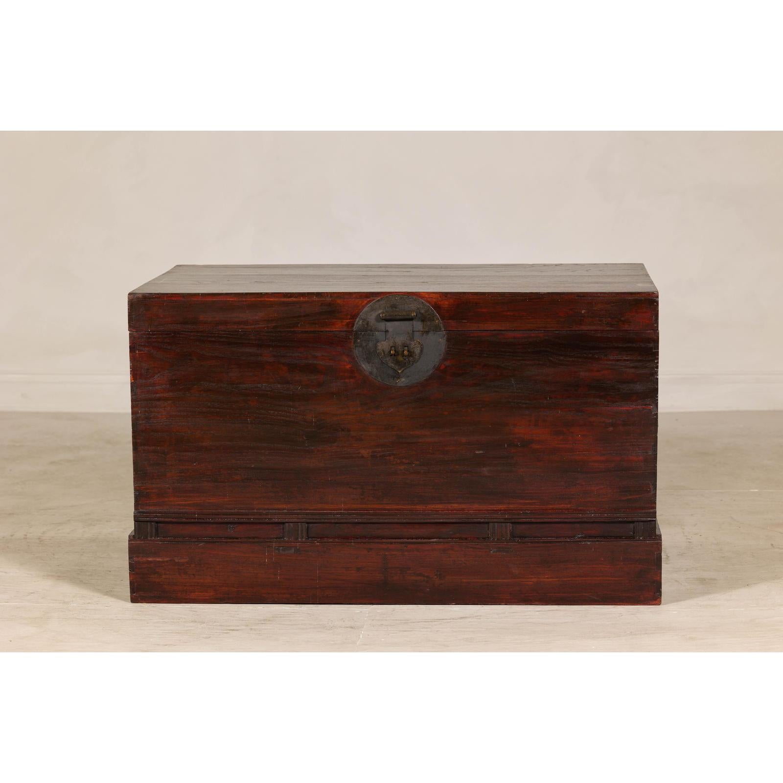 Antique Reddish Brown Lacquered Elm Trunk with Brass Lock and Raised Base