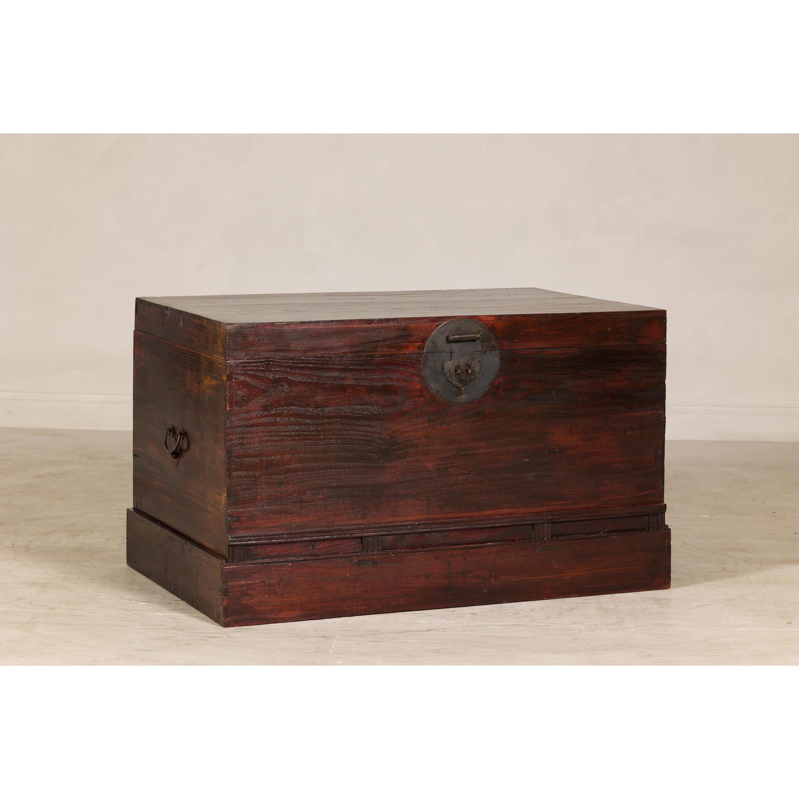 Antique Reddish Brown Lacquered Elm Trunk with Brass Lock and Raised Base