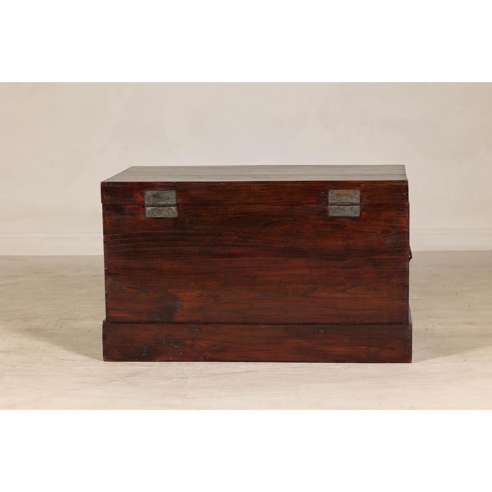 Antique Reddish Brown Lacquered Elm Trunk with Brass Lock and Raised Base