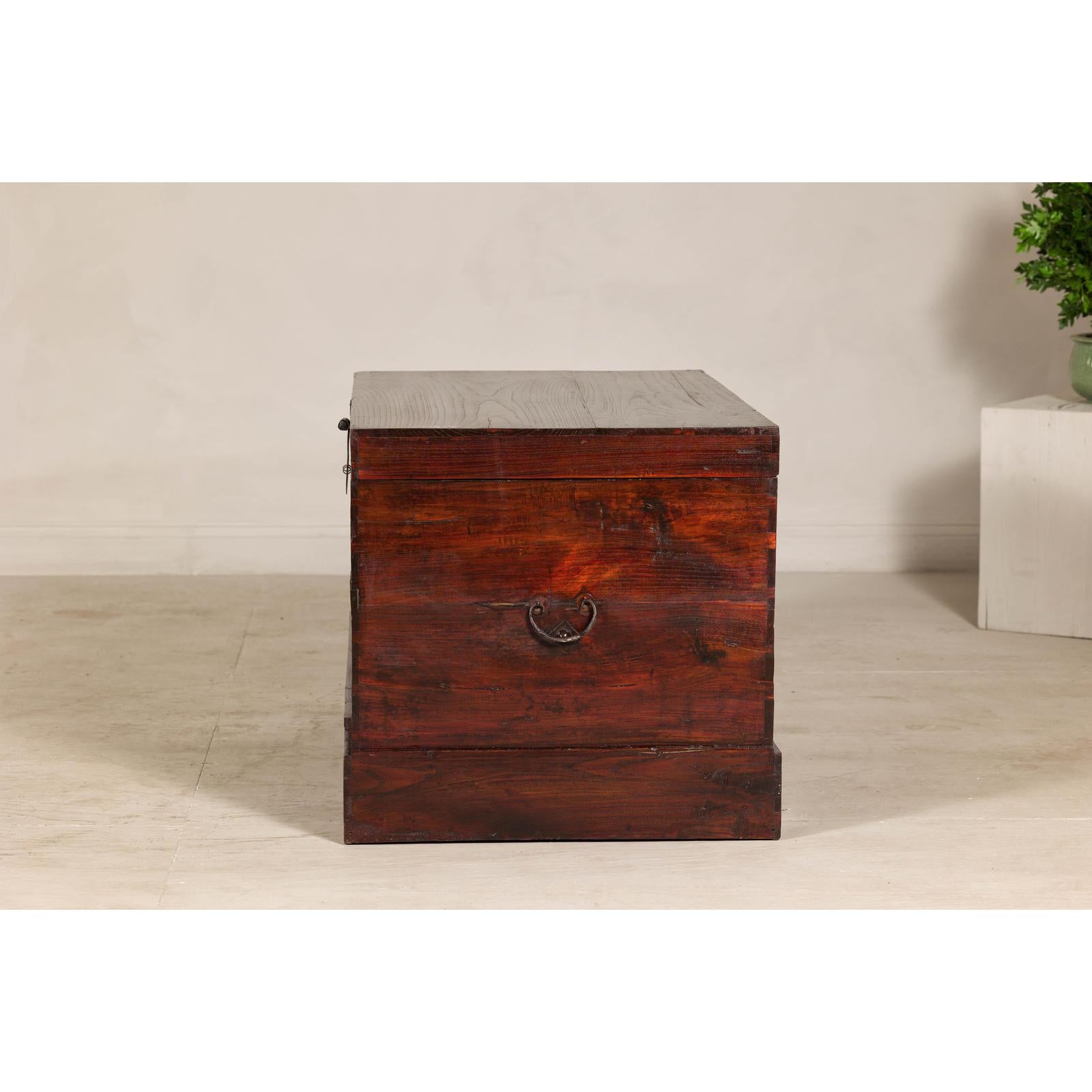 Antique Reddish Brown Lacquered Elm Trunk with Brass Lock and Raised Base