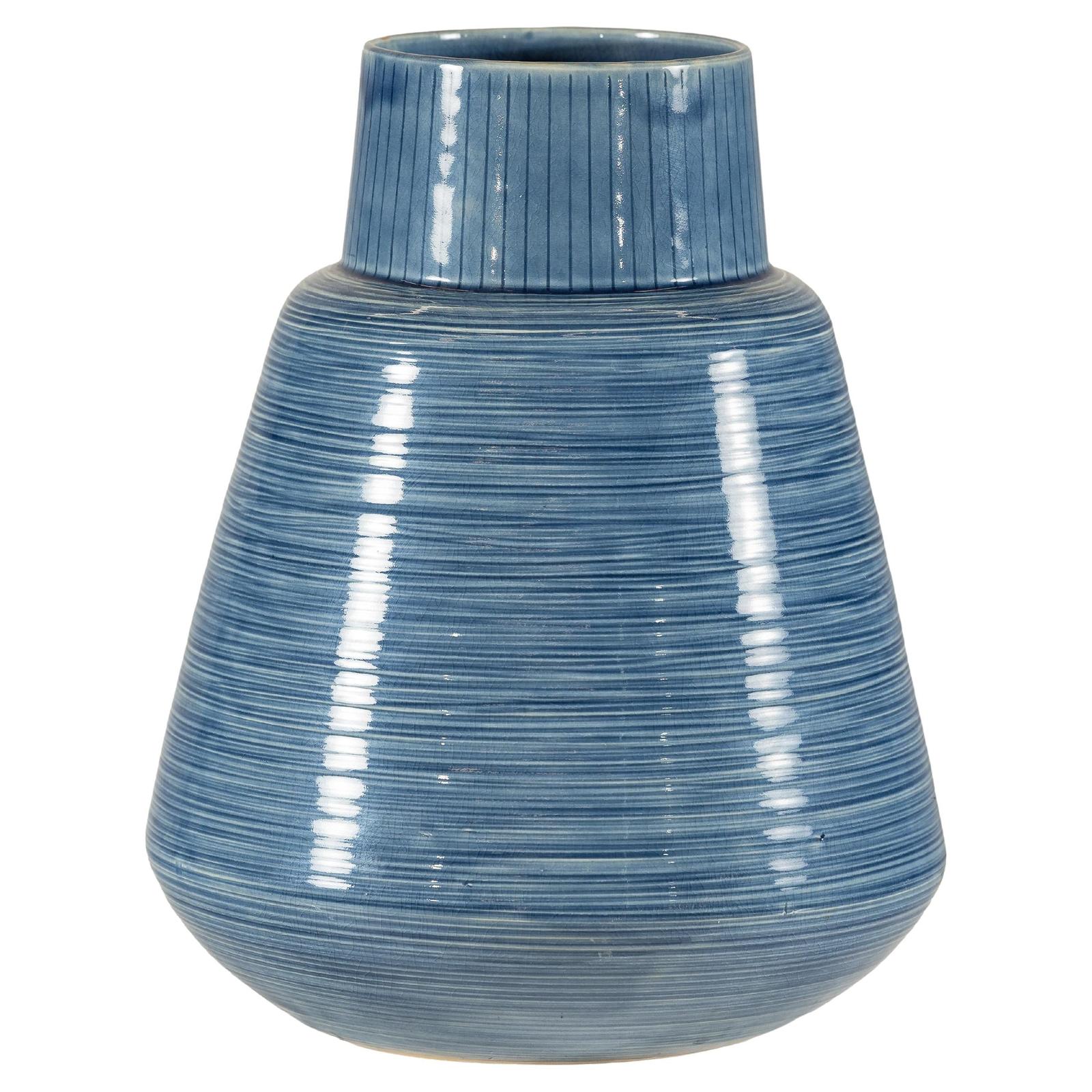 Close-up of blue-glazed ceramic vase with wide base, narrow neck, and textured horizontal lines.