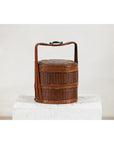 Brown vintage woven carrying box with double handles on a white surface, plain background.