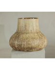 Textured cream and earth toned ceramic vase on white pedestal against plain background.