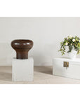 Dark studio pottery bowl and large speckled brown ceramic vase with wide mouth on white wooden boxes.
