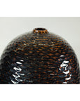 Close-up of a deep brown and black ceramic vase with honeycomb texture and small top opening.