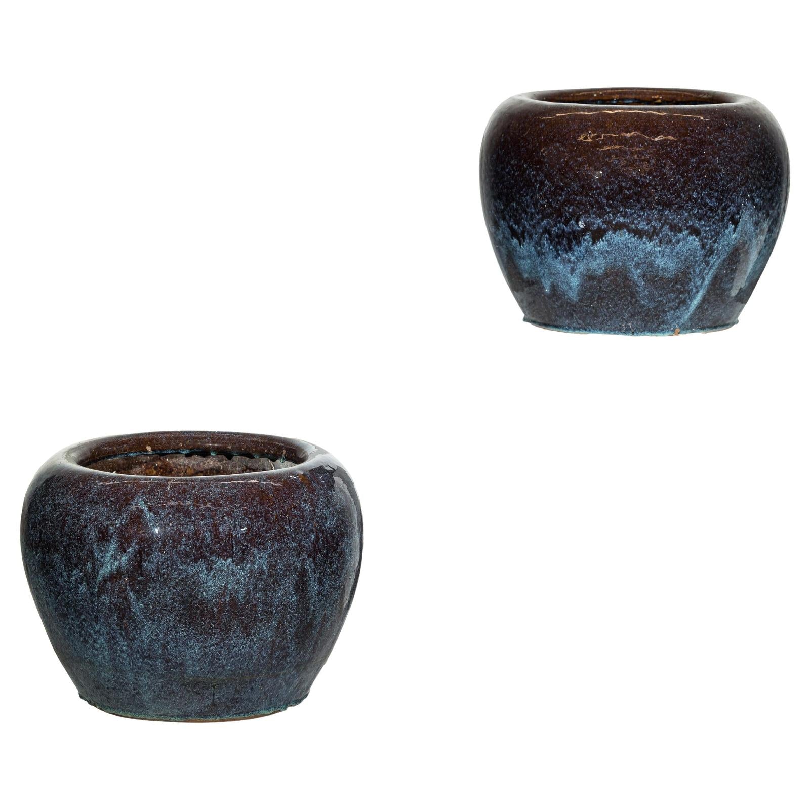 Close-up of vintage blue and aqua glazed ceramic planters, pair on white background.