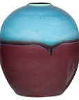 Close-up of round ceramic vase with turquoise glazed top, brown bottom, and small opening, modern style.