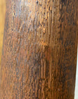 Close-up of a textured brown and copper ceramic vase against a textured brown background.