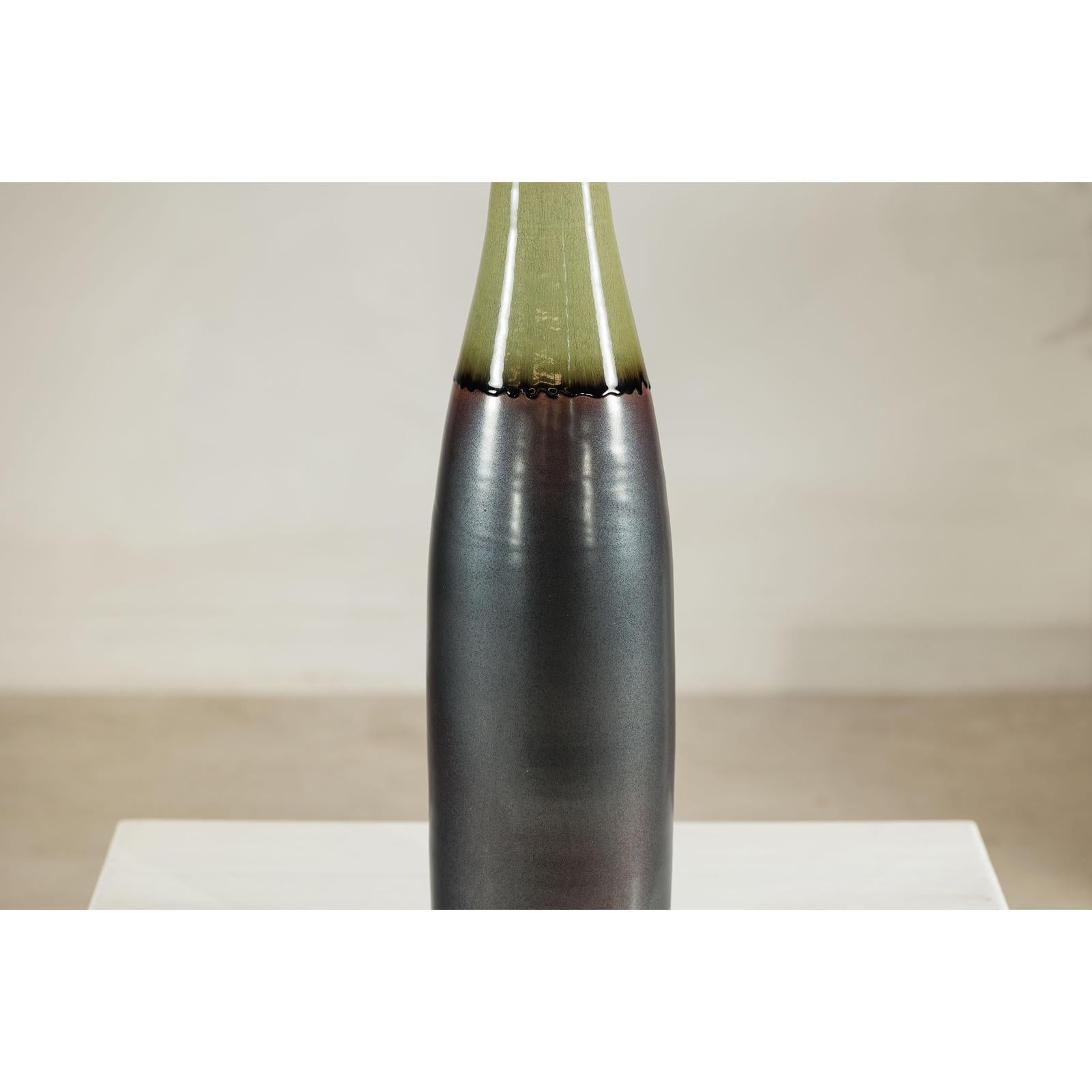 Charcoal ceramic vase with moss green glazed neck, bottle silhouette, close-up.