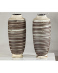 Close-up of two tall ceramic vases with horizontal swirl design, displayed on a white surface.
