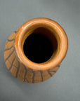 Sand brown and orange ceramic vase with black crackle design, viewed from above.