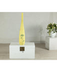 Yellow ceramic vase with hand-painted flowers on white chest, next to white vase with flowers, indoor setting.