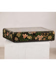 Black lacquer box with floral and bird design, felt interior, displayed on a white wooden pedestal.