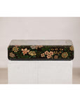 Black lacquer box with painted flowers and birds, felt interior, displayed on a white pedestal against plain background.