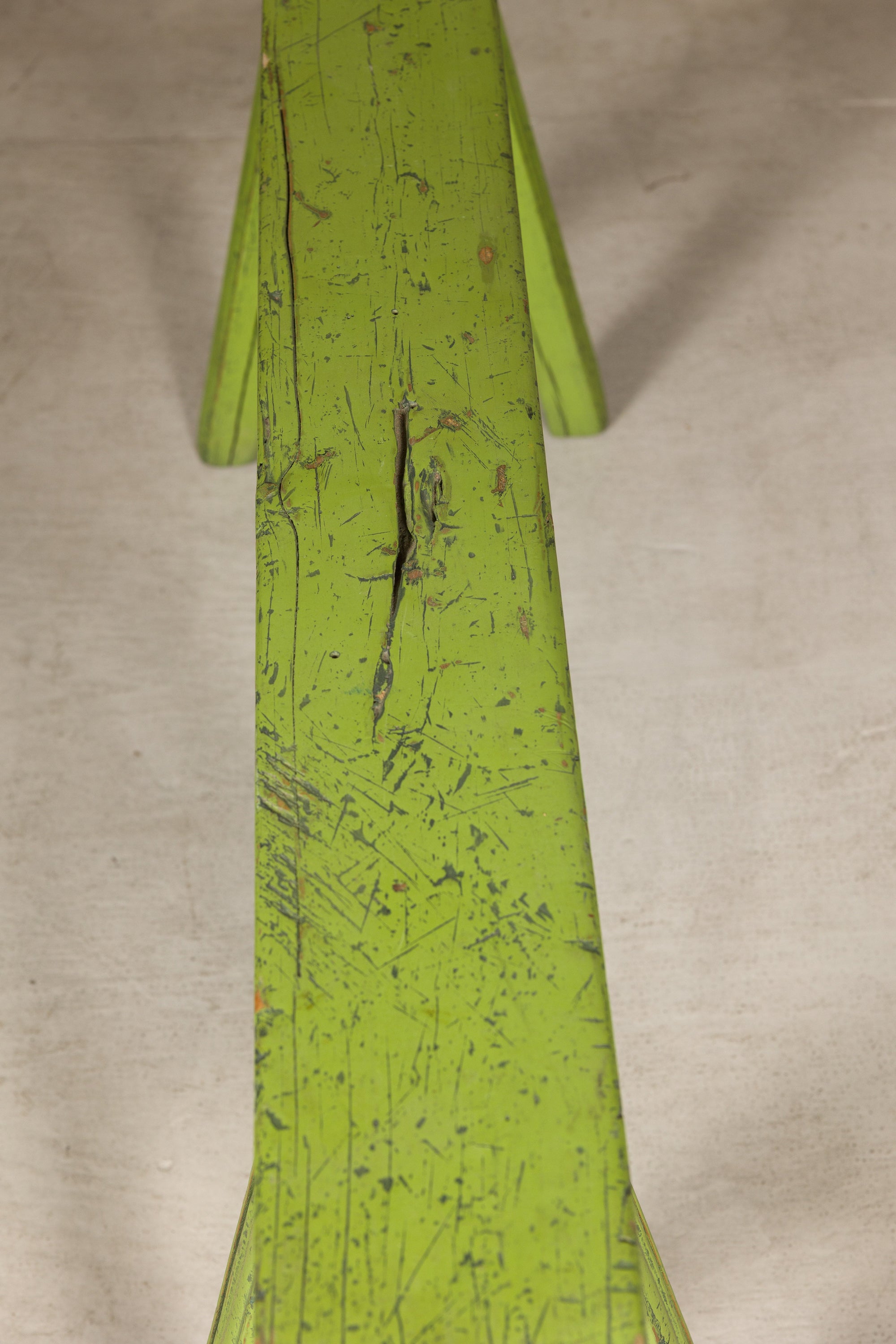 Close-up of curved bench seat with distressed green paint