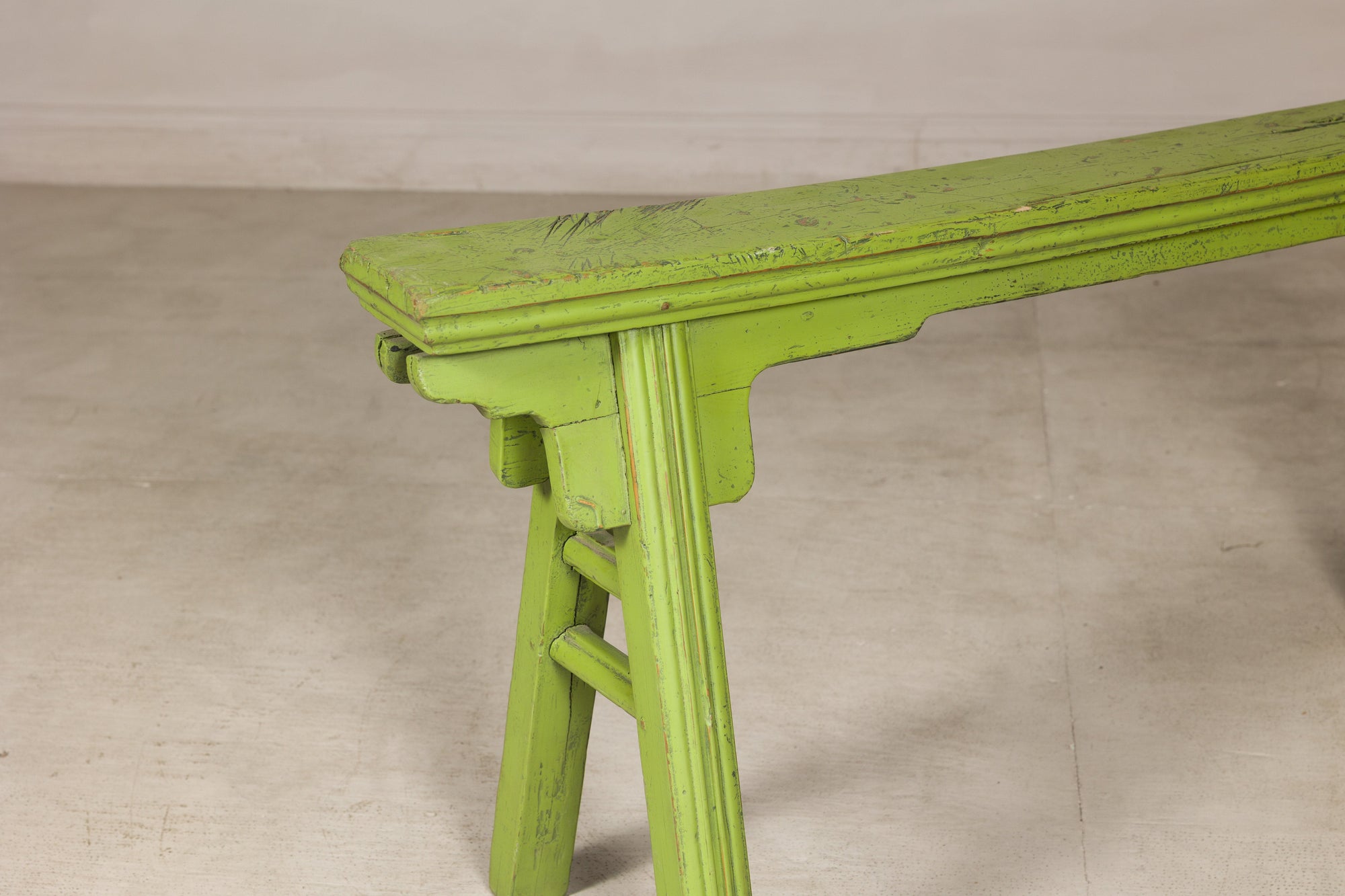 Green painted Chinese bench, close-up of left end and seat