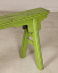 Green painted bench with A-frame supports, three-quarter end view