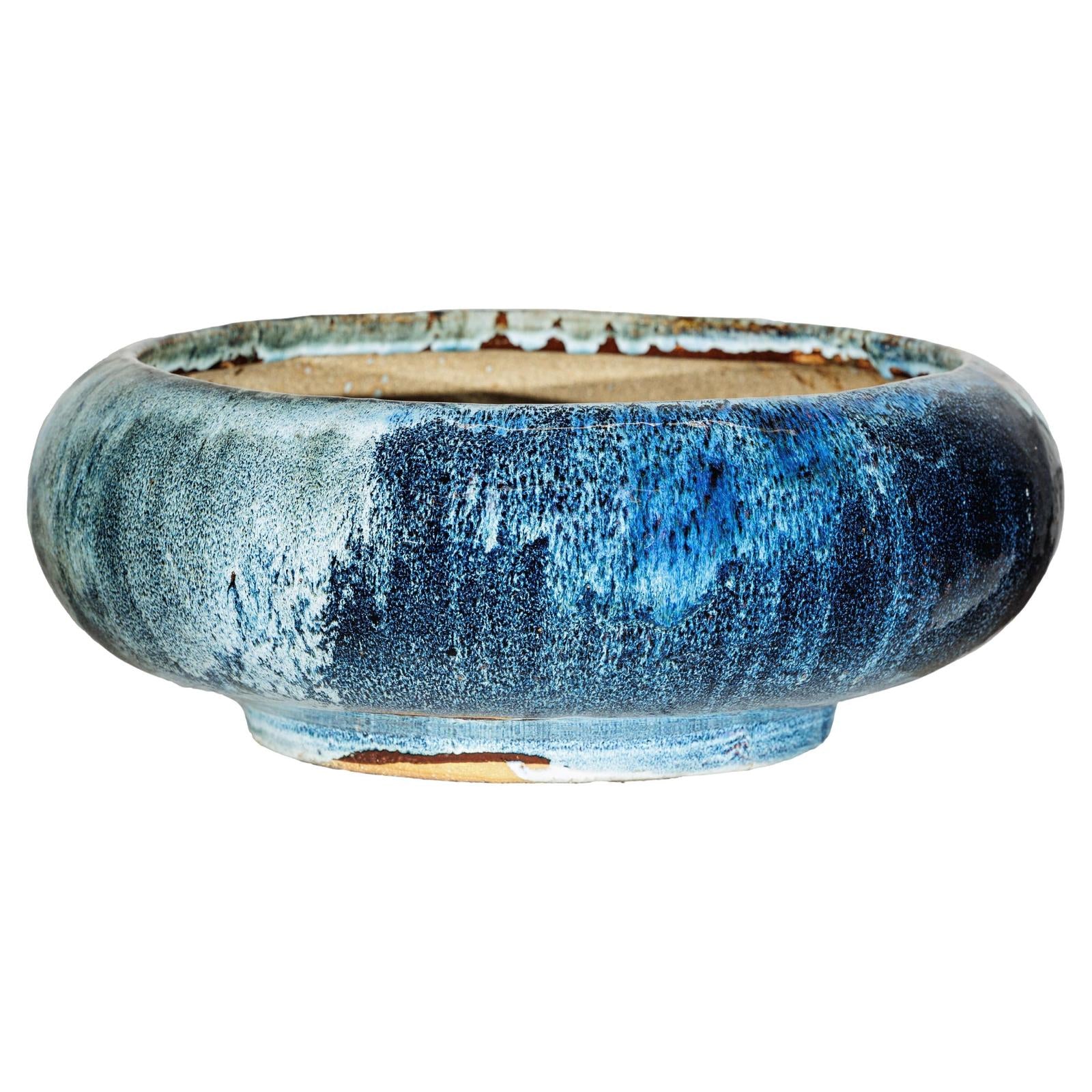 Close-up of blue and white glazed ceramic Shigaraki style low planter with wide opening.