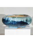 Blue ceramic Shigaraki-style low planter with wide opening on a white pedestal, plain background.