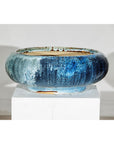 Blue ceramic Shigaraki-style low planter with wide opening on white pedestal, plain background.