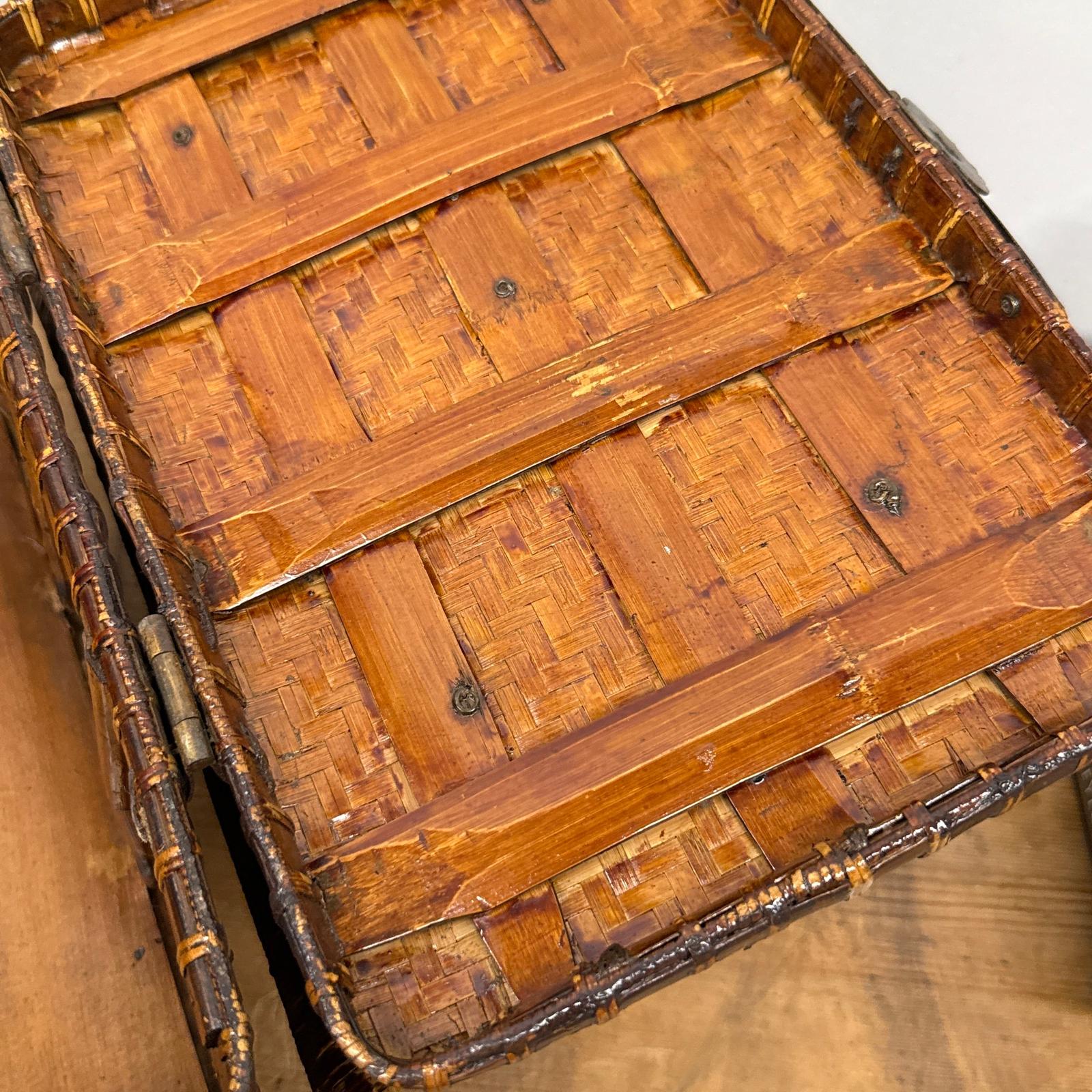 Close-up of the Woven Rectangular Picnic Basket with Handle &amp; Hinged Lid, highlighting its intricate bamboo strips, wooden supports, and natural brown finish—a testament to Southeast Asian craftsmanship on a wooden surface.