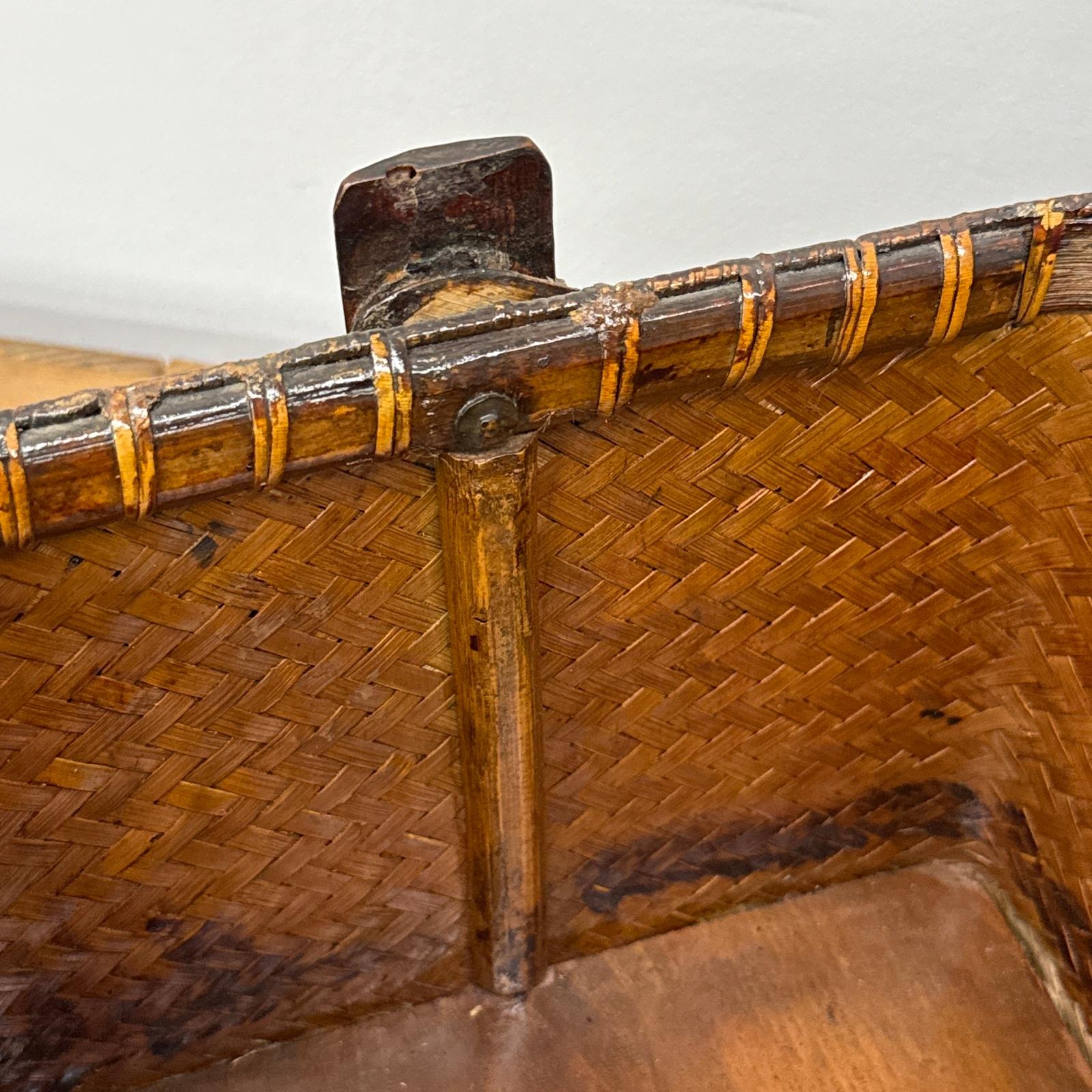 Close-up of the Woven Rectangular Picnic Basket with Handle &amp; Hinged Lid, featuring a reinforced wooden rim and vertical support post with metal fastener. The aged wood highlights Southeast Asian craftsmanship.